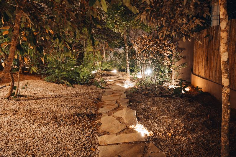 Caminho de pedra iluminado que leva ao bangalô Abraço