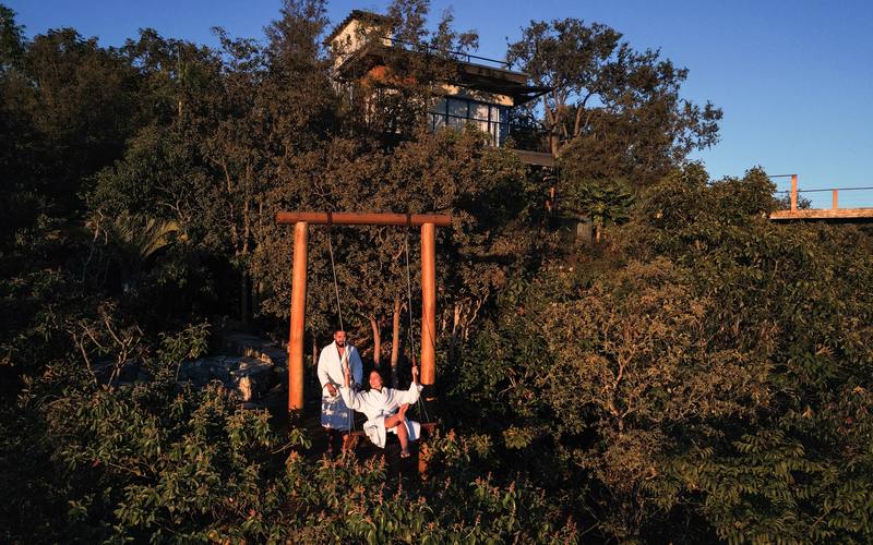 Balanço suspenso da Villa Eyá visto de cima, com o bangalô acima na encosta