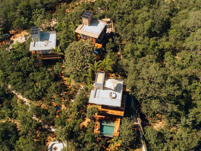 Bangalôs da Villa Eyá vistos do alto, cada um com sua piscina, separados pela mata do cerrado
