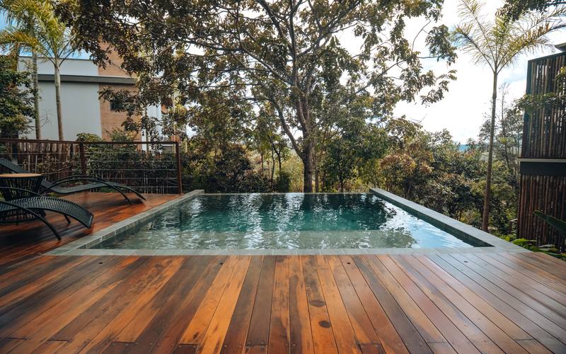 Piscina do bangalô Sorriso com deck de madeira e espreguiçadeiras