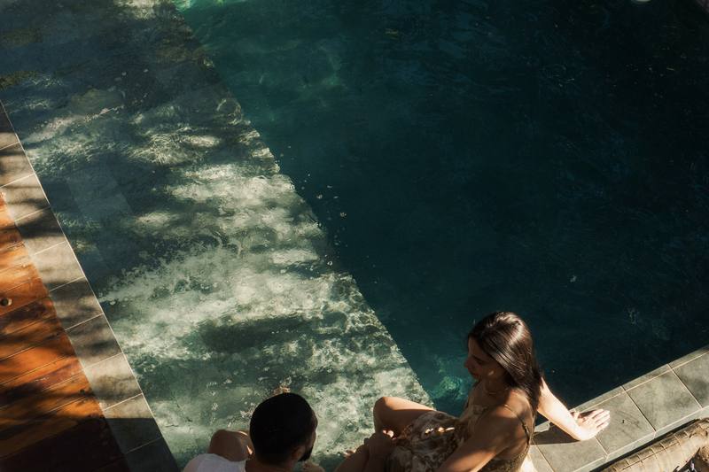 Piscina do bangalô Sorriso vista de cima, com hóspede sentada na borda